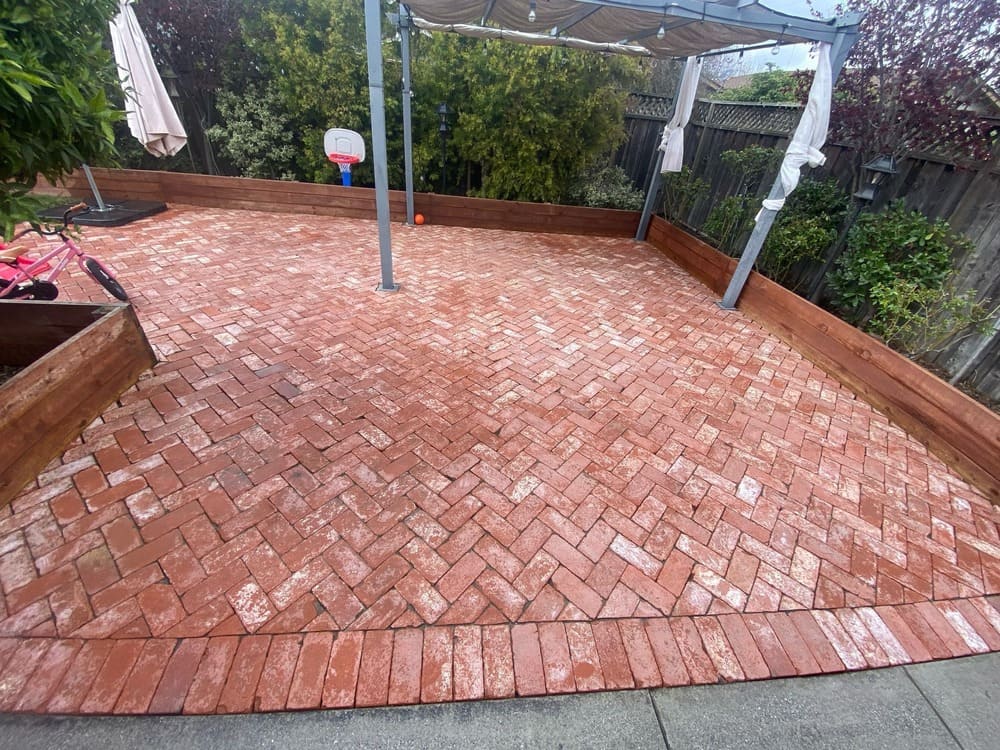 Pressure washing removing dirt buildup from bricks in San Mateo, CA.